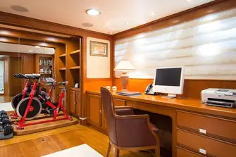 Behind a wardrobe door in the owner's office, there are weights and an exercise bike that swivels out
