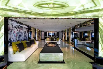 Backlit onyx welcomes guests into the main saloon with its huge TV to starboard and formal dining forward beneath a custom-made lighting installation