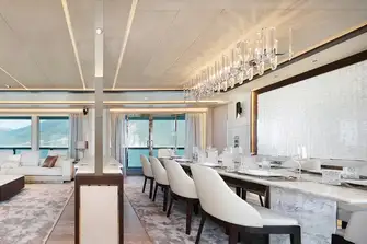The dining room, forward in the main saloon, benefits from excellent natural light through full-height windows and glazed bulwark cut-outs