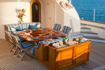 Aft of the main saloon is a dining area partially shaded by the aft flybridge