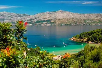 Sheltered Lovrečina beach on the island's northern coast, with the mountainous mainland across the water